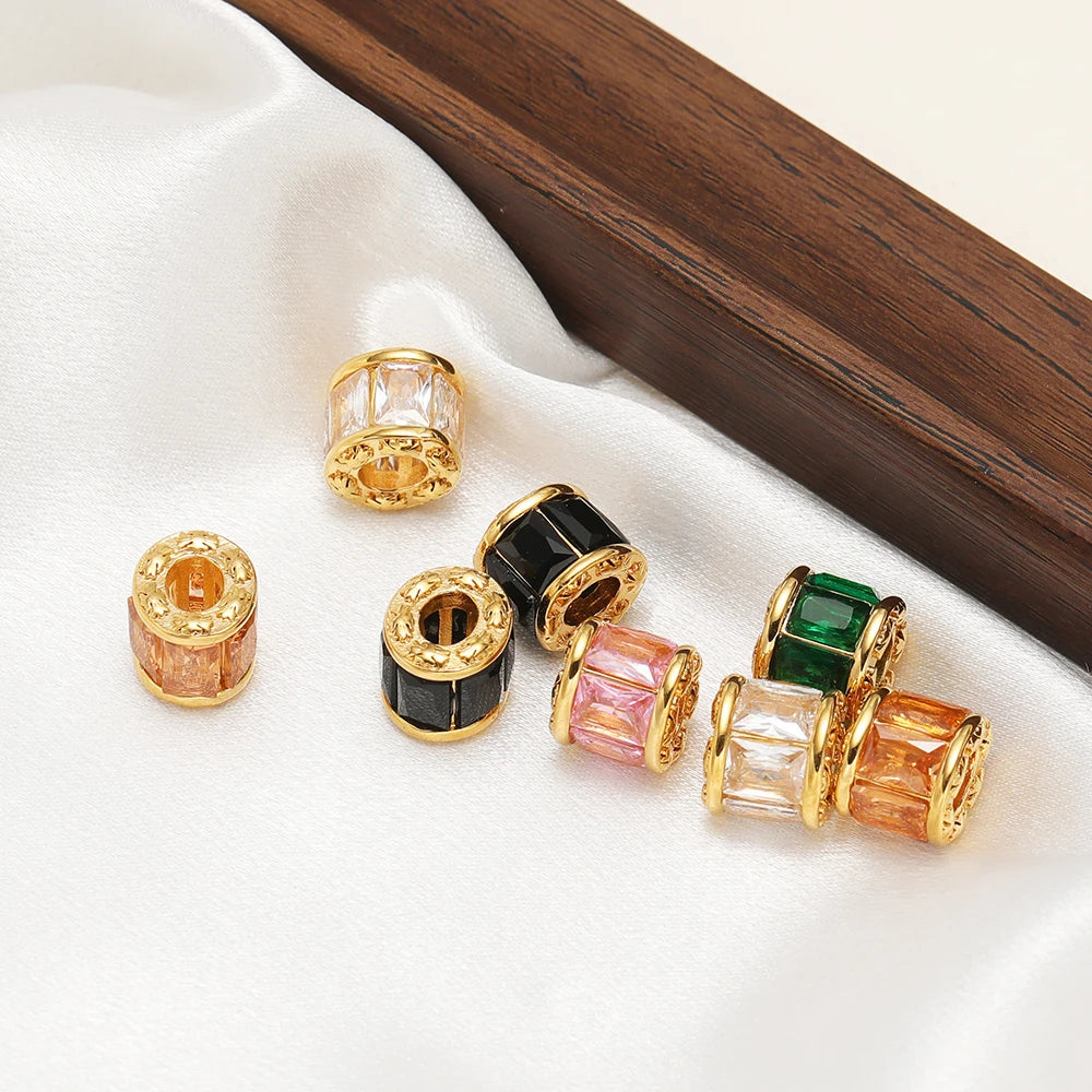 Gold-plated spacer beads set with green, black, pink, peach, and orange tones