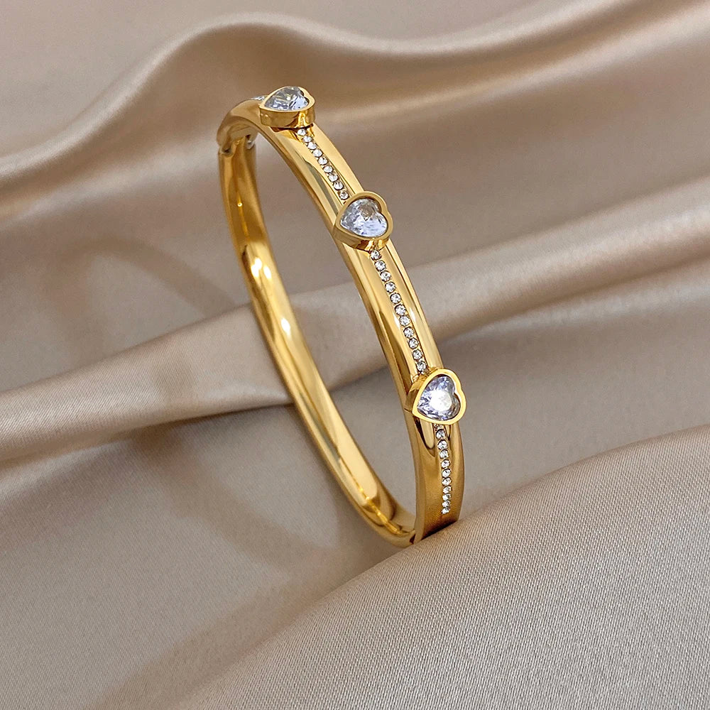 Gold-tone heart-stone bangle bracelet with clear round gems on the band