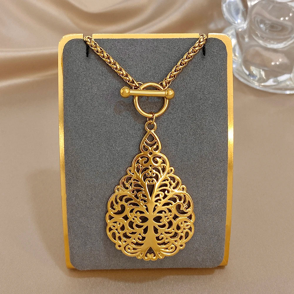 Gold-tone decorative teardrop charm necklace with loop clasp and filigree center