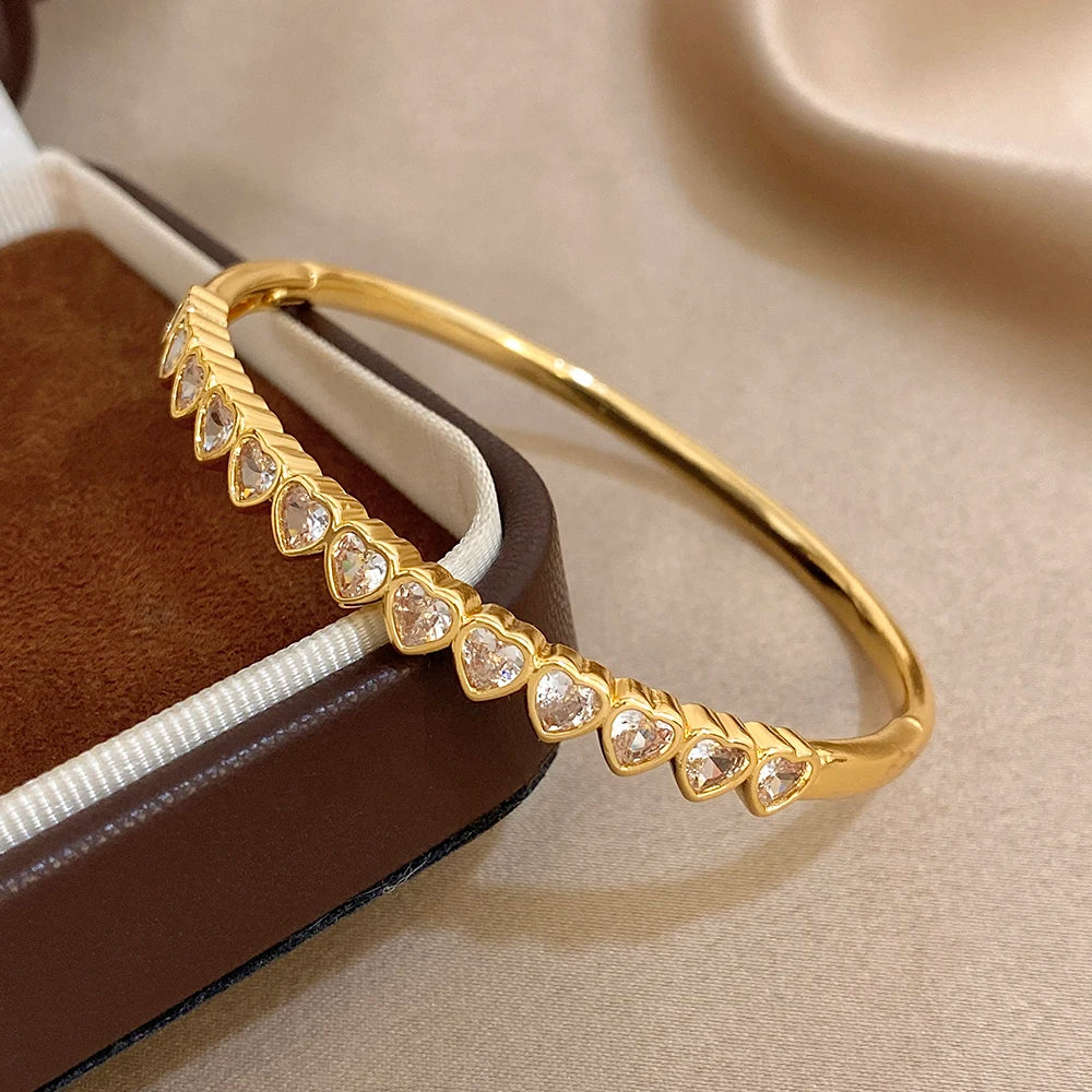 Gold-tone heart crystal inlay bangle bracelet, angled close-up