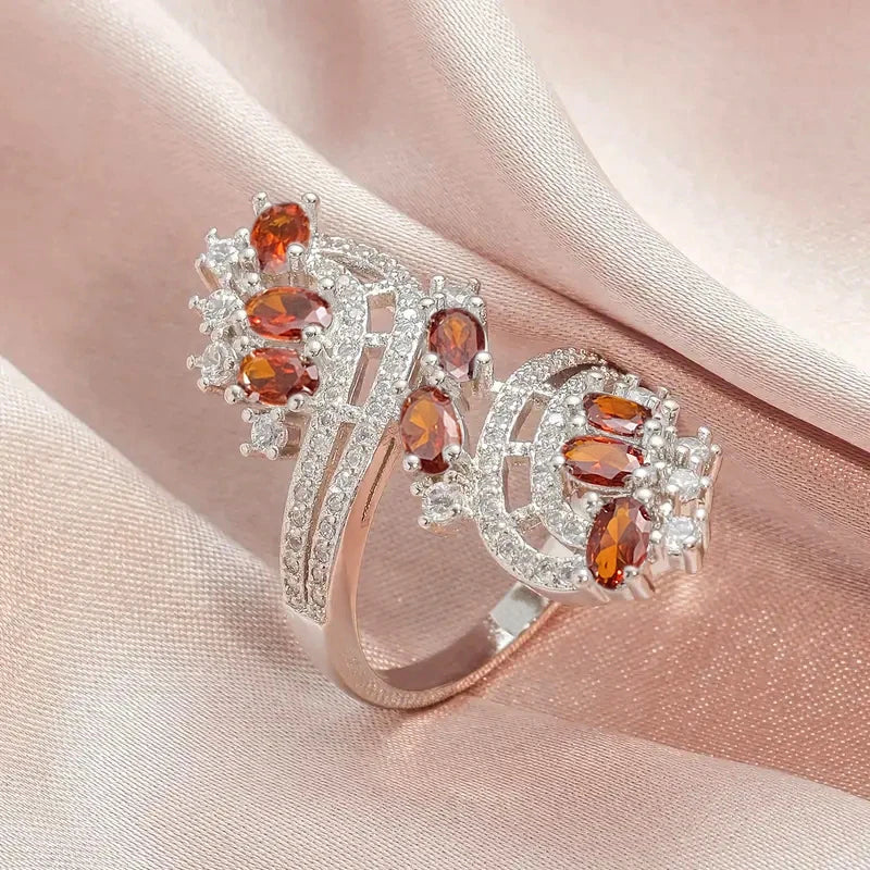 Rose-gold cubic zirconia bridal ring with orange oval stones and curved halo sparkle