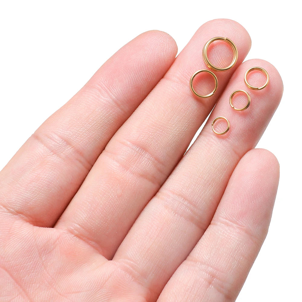 Gold open jump rings close-up on hand, small double-loop split rings