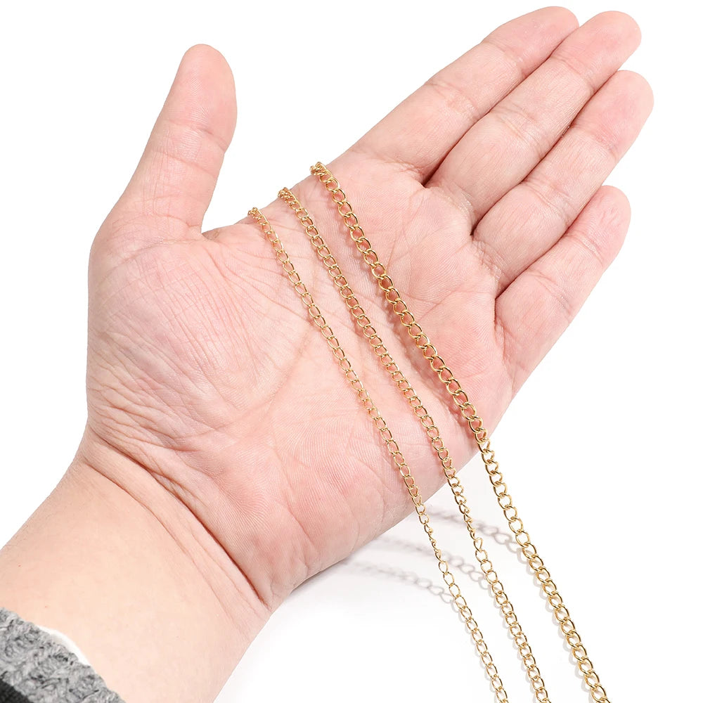 Gold tone chain extension on open palm, fine curb-style links for jewelry