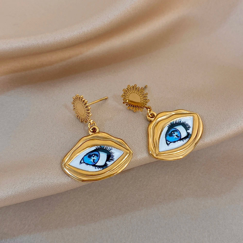 Gold-tone evil eye drop earrings with blue eye enamel and textured sunburst accents