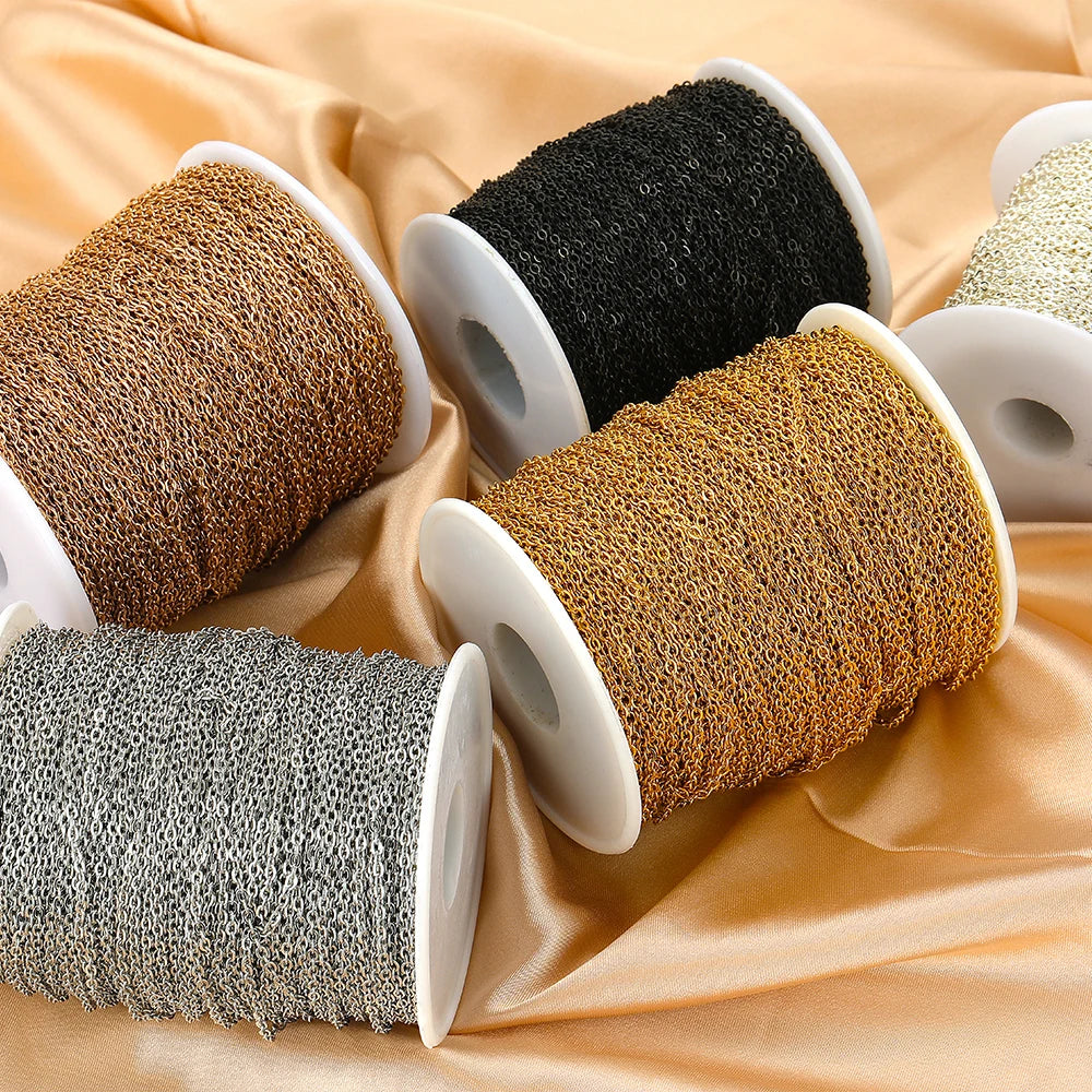 Stainless steel chain links on spools in copper, black, gold, and light silver