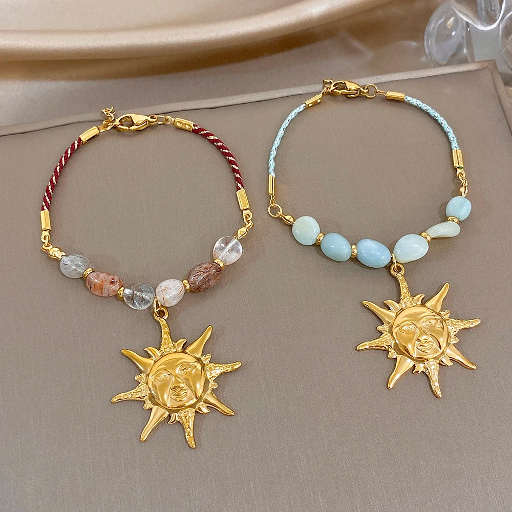 Beaded rope chain bracelet with red and clear stones and gold sun face charm