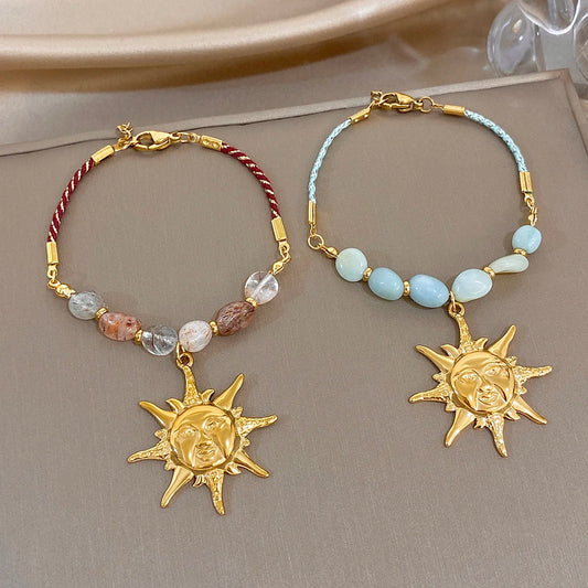Beaded rope chain bracelet with red and clear stones and gold sun face charm