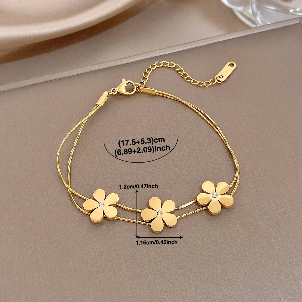 Gold double-layer snake chain bracelet with five flower charms and crystal centers, with size notes