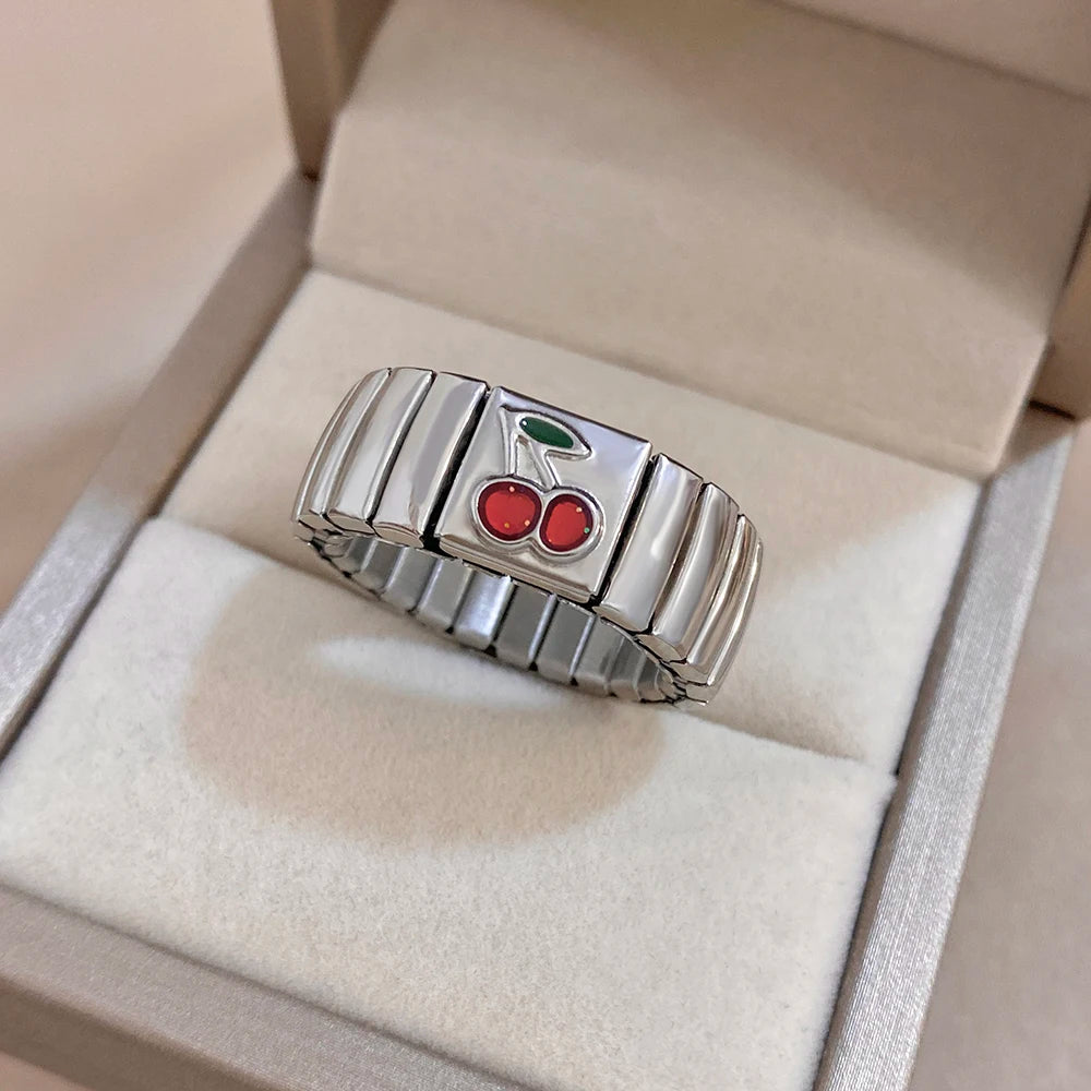 Silver adjustable watchband-style finger ring with red cherry enamel and green leaf accents