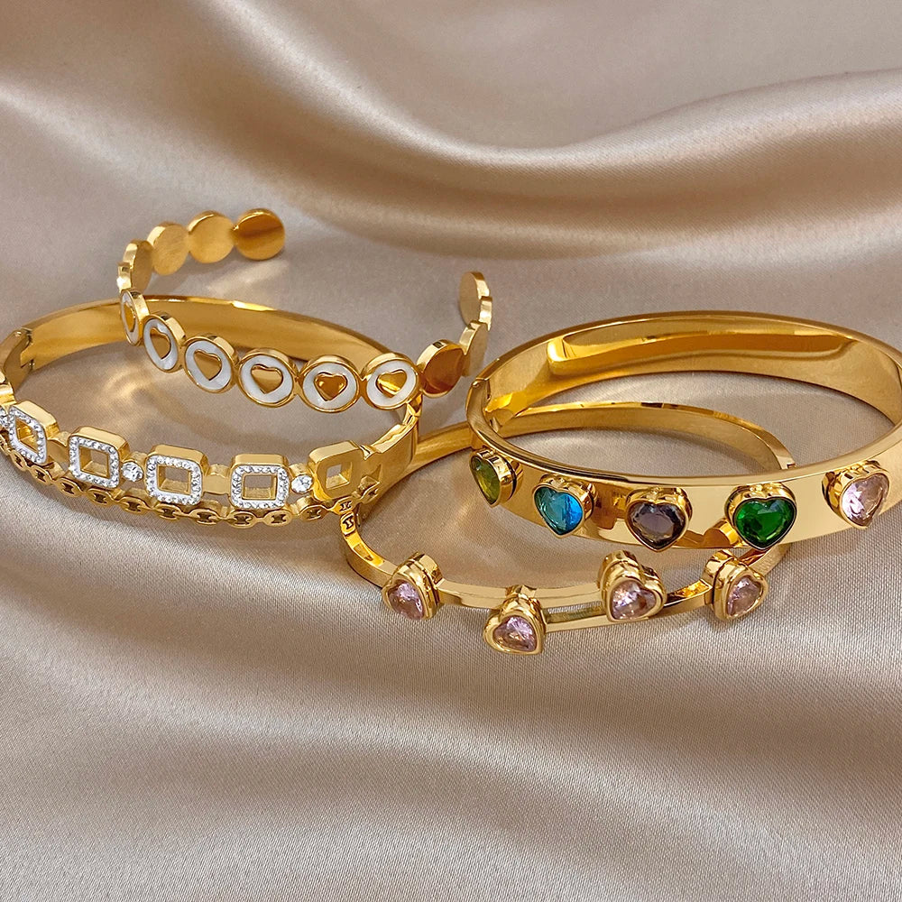 Gold-plated cuff bangles with heart insets and colorful oval zircon stones, wide bands