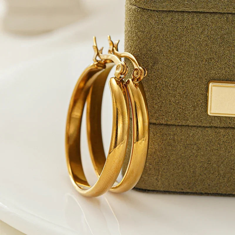Gold-tone stainless steel hoop earrings, overlapping pair close-up