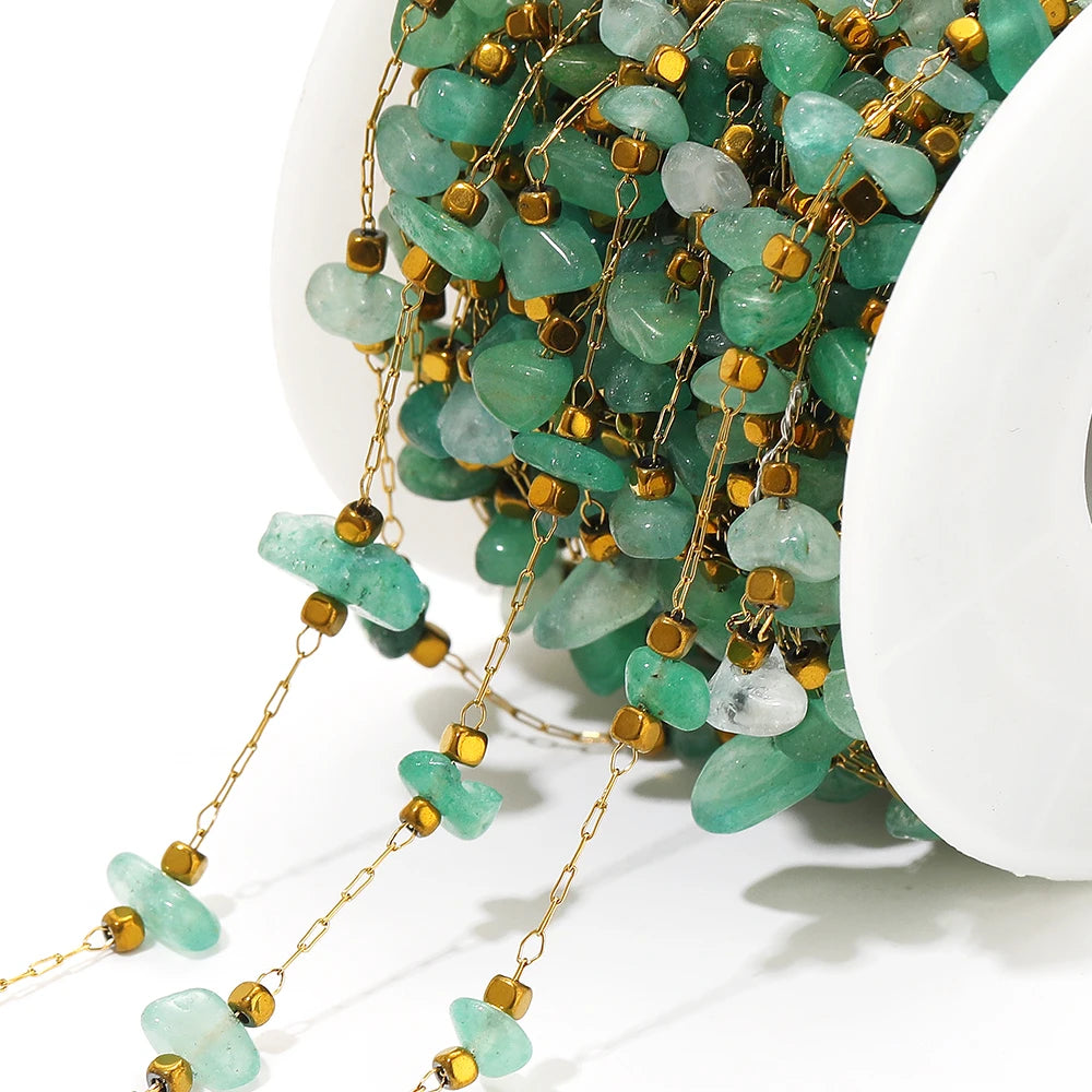 Close-up irregular glass bead link chain with green teardrop beads and gold-tone caps