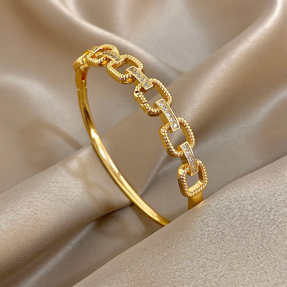 Gold-tone geometric square-link cuff bracelet with clear zircon accents and hinge clasp