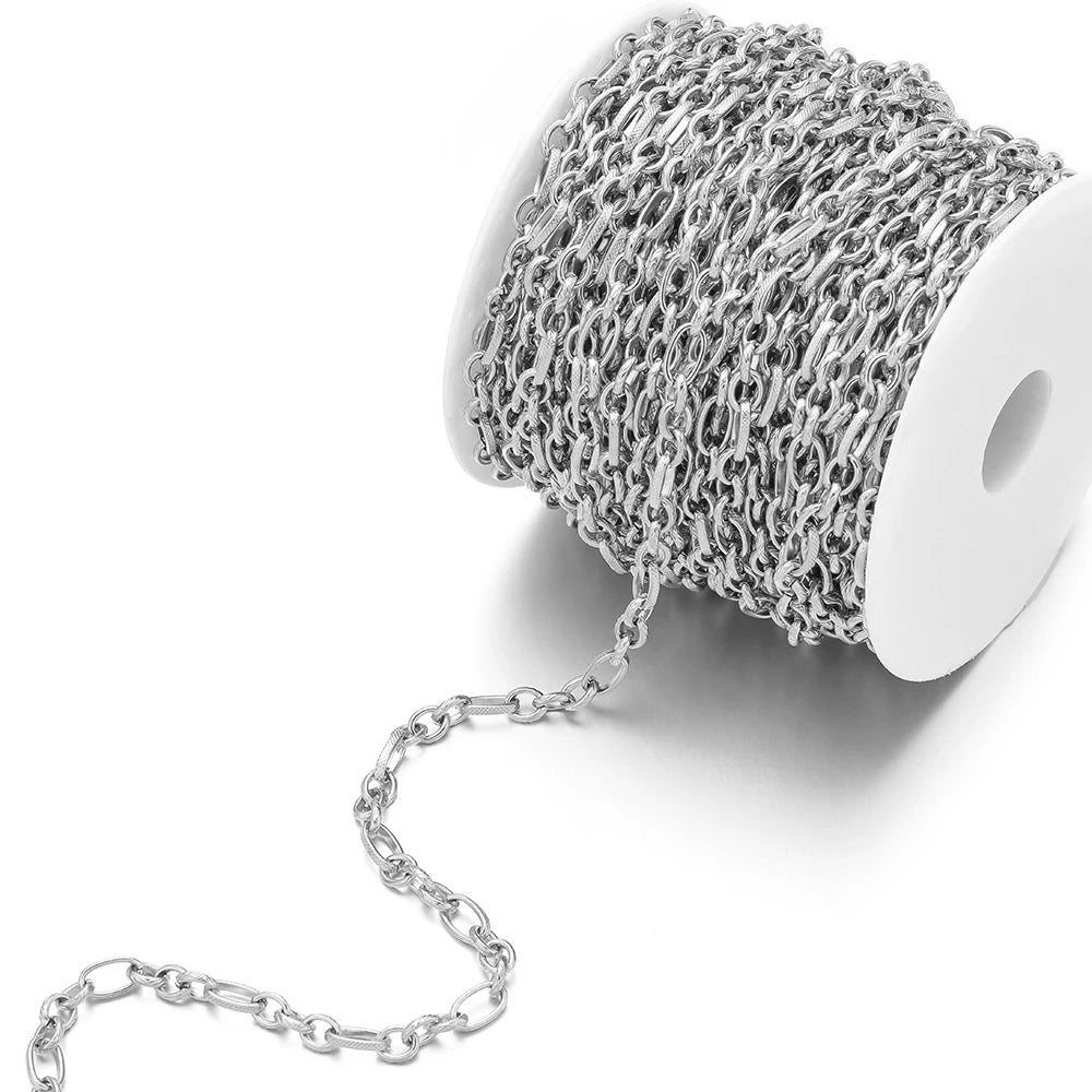 Silver flat link chain roll on white spool, shiny oval links