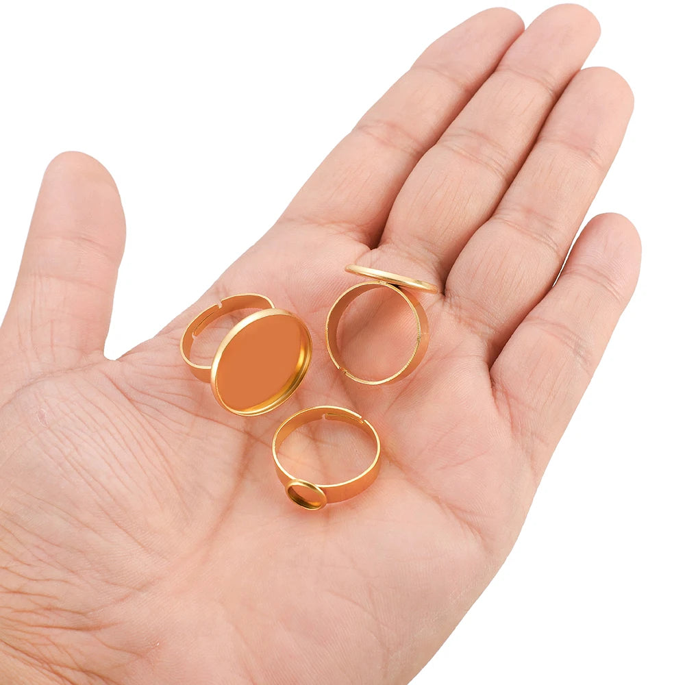 Gold adjustable ring bezel blanks for cabochons, shown on open palm