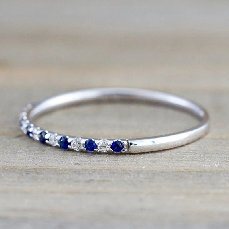Silver ring with row of blue CZ stones along the band