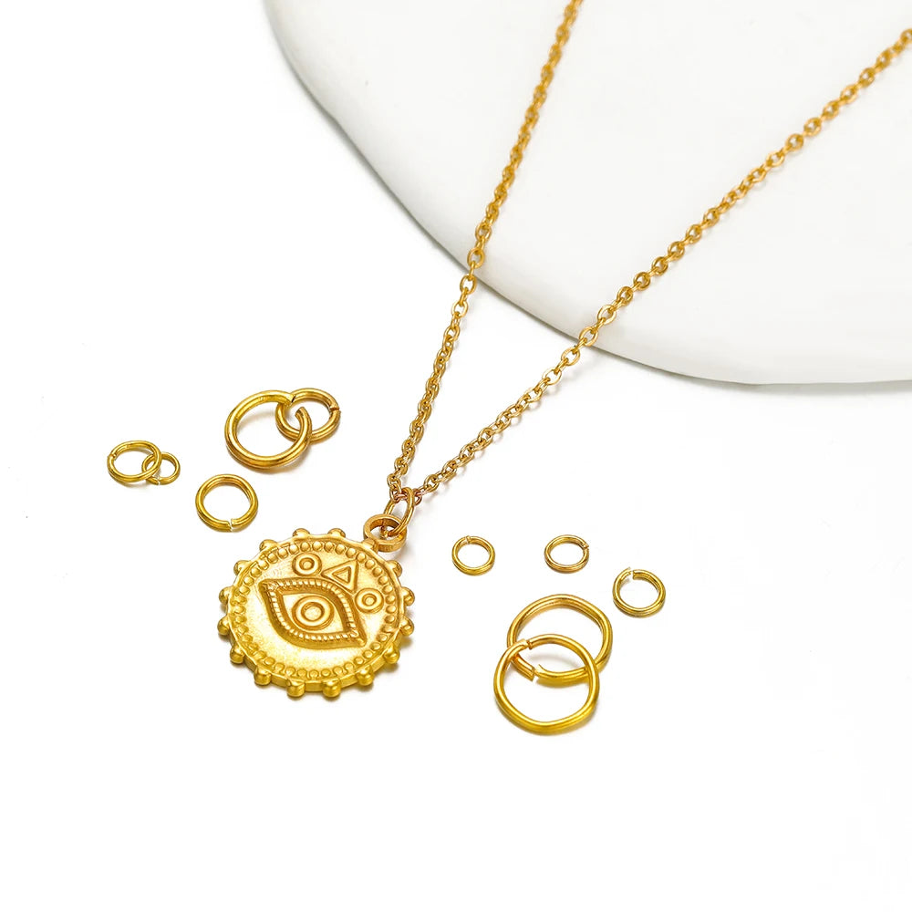 Gold-colored jump rings with a small coin pendant necklace and chain