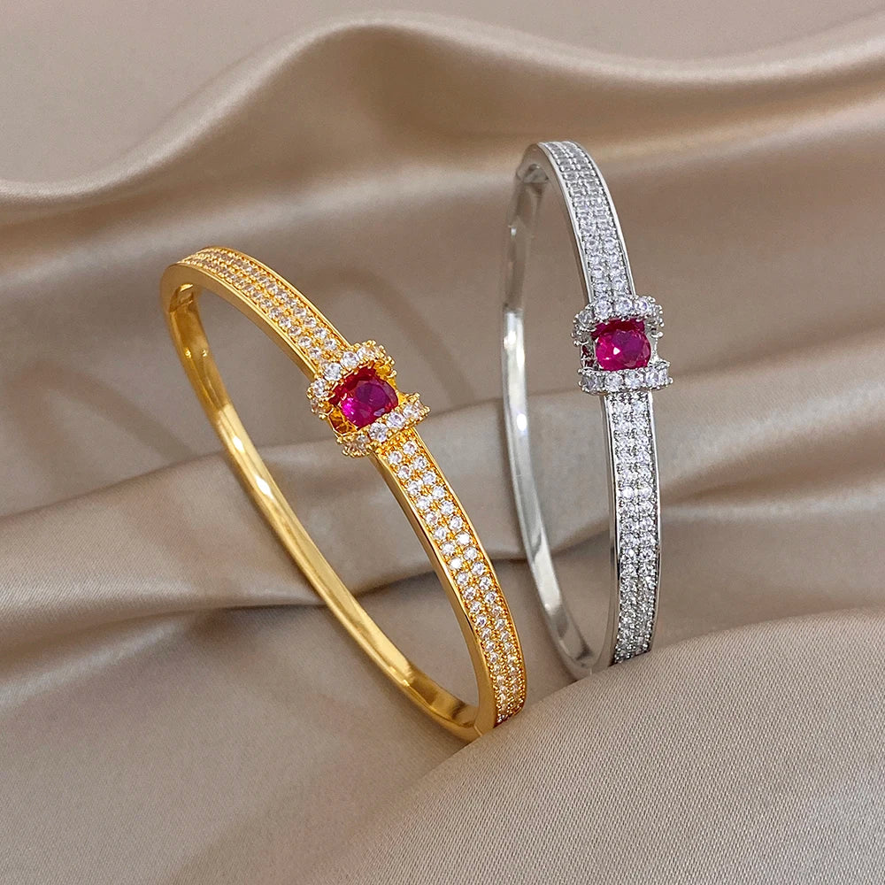 Gold and silver zircon cuff bangles with pink round center stones and crystal pave rows