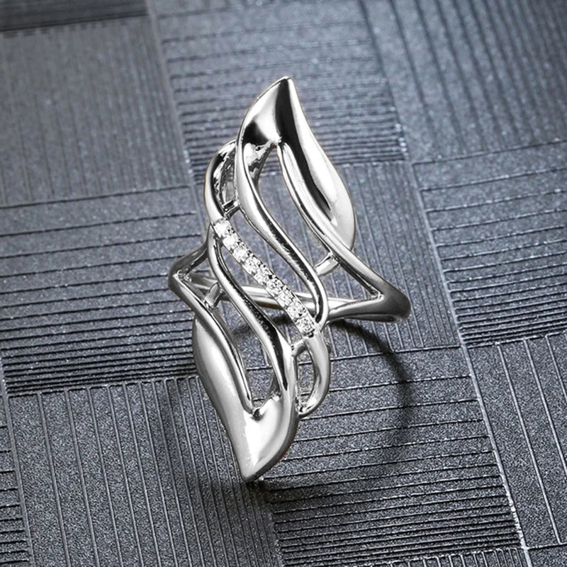 Geometric hollow silver ring with openwork leaf-like design and clear stone accent