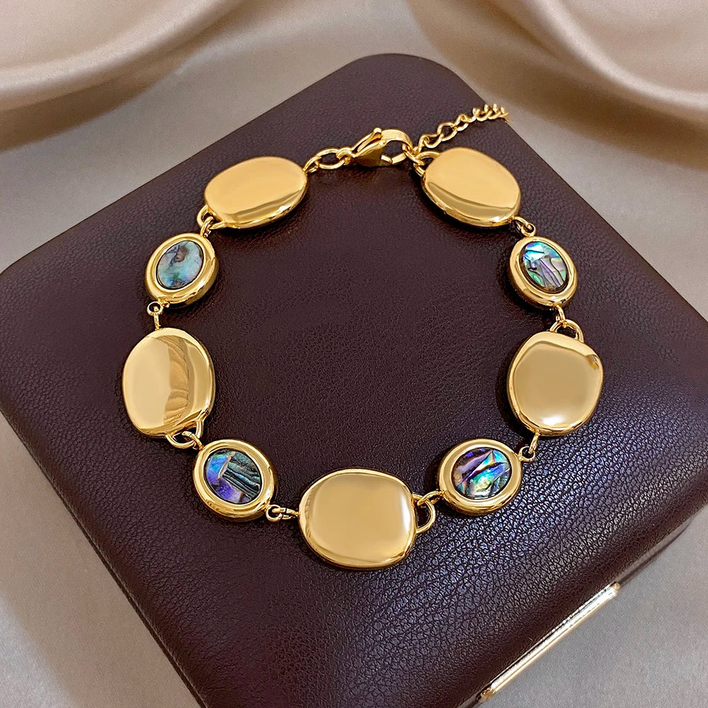 Gold-tone oval-link bracelet with glossy discs and iridescent abalone shell inlay beads