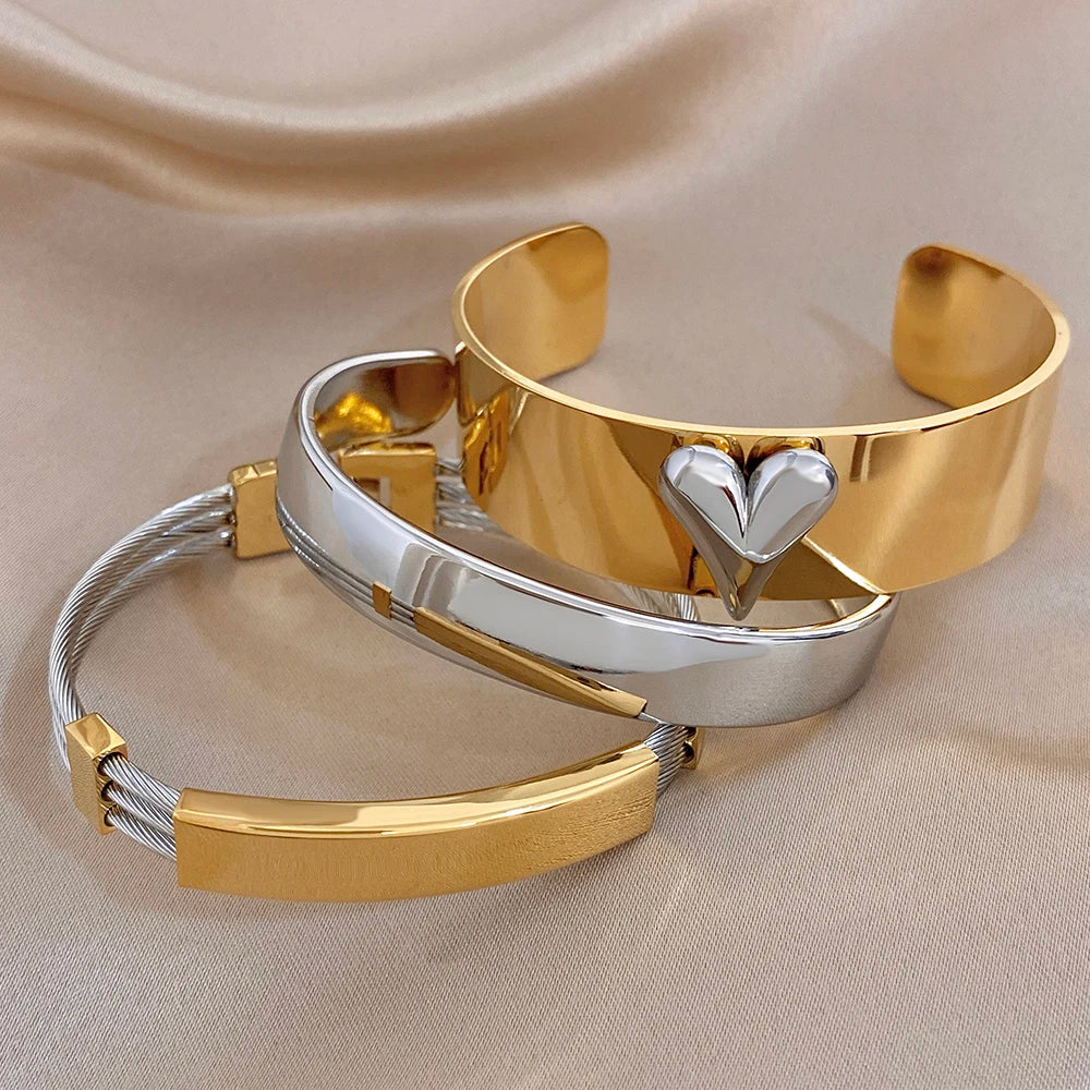 Gold and silver glossy cuff bangles with heart charm center and chunky flat profile