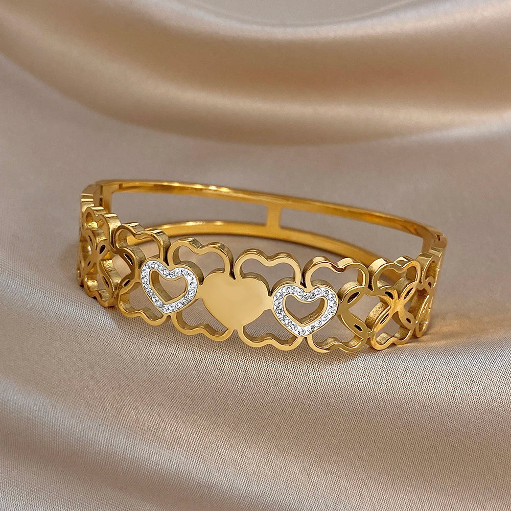 Gold open cuff bangle with heart cluster motif and clear rhinestone accent stones