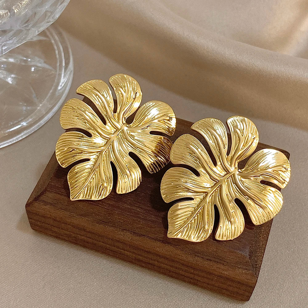 Pair of oversized gold leaf stud earrings with sculpted vein details