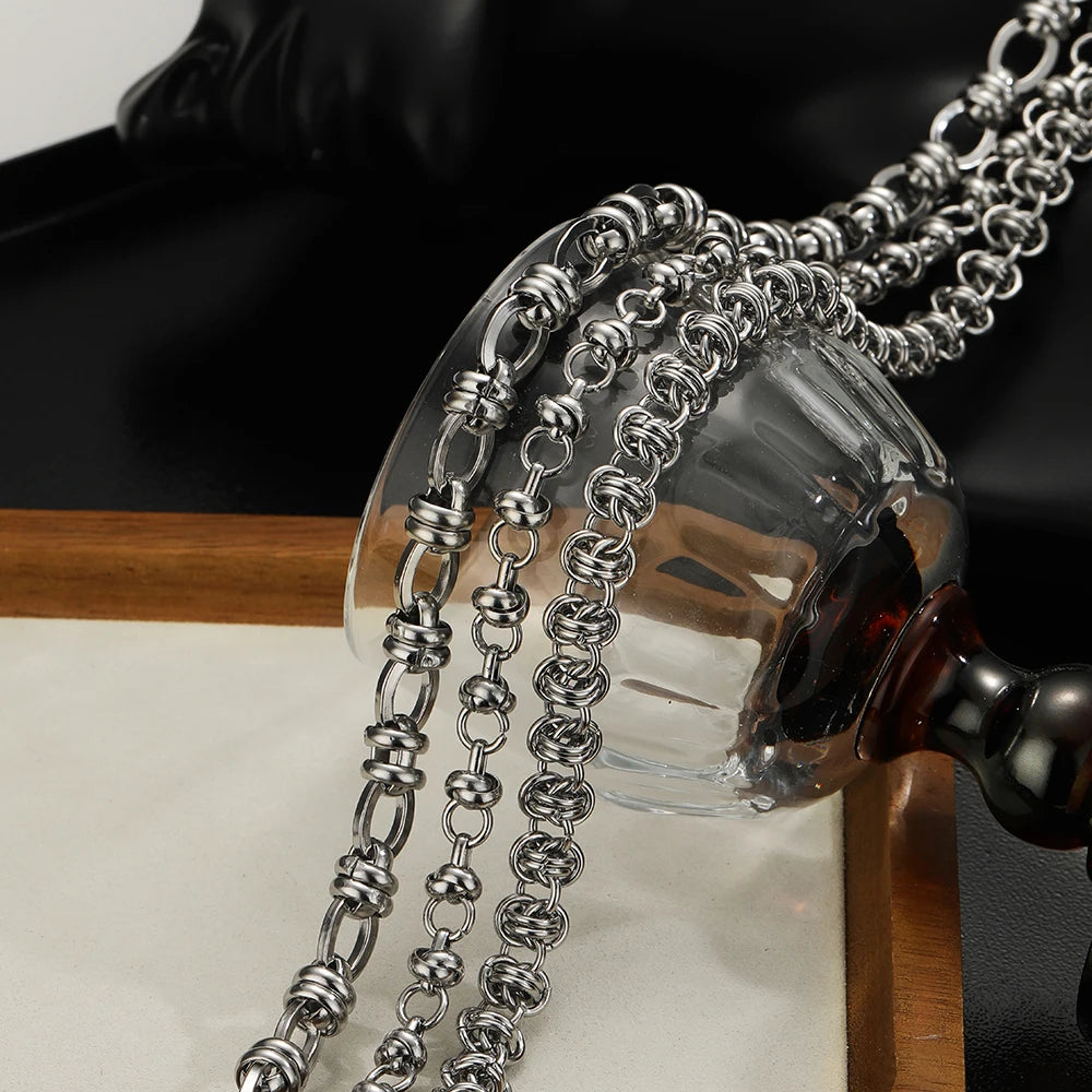 Stainless steel chain draped around a clear glass holder, punk jewelry making