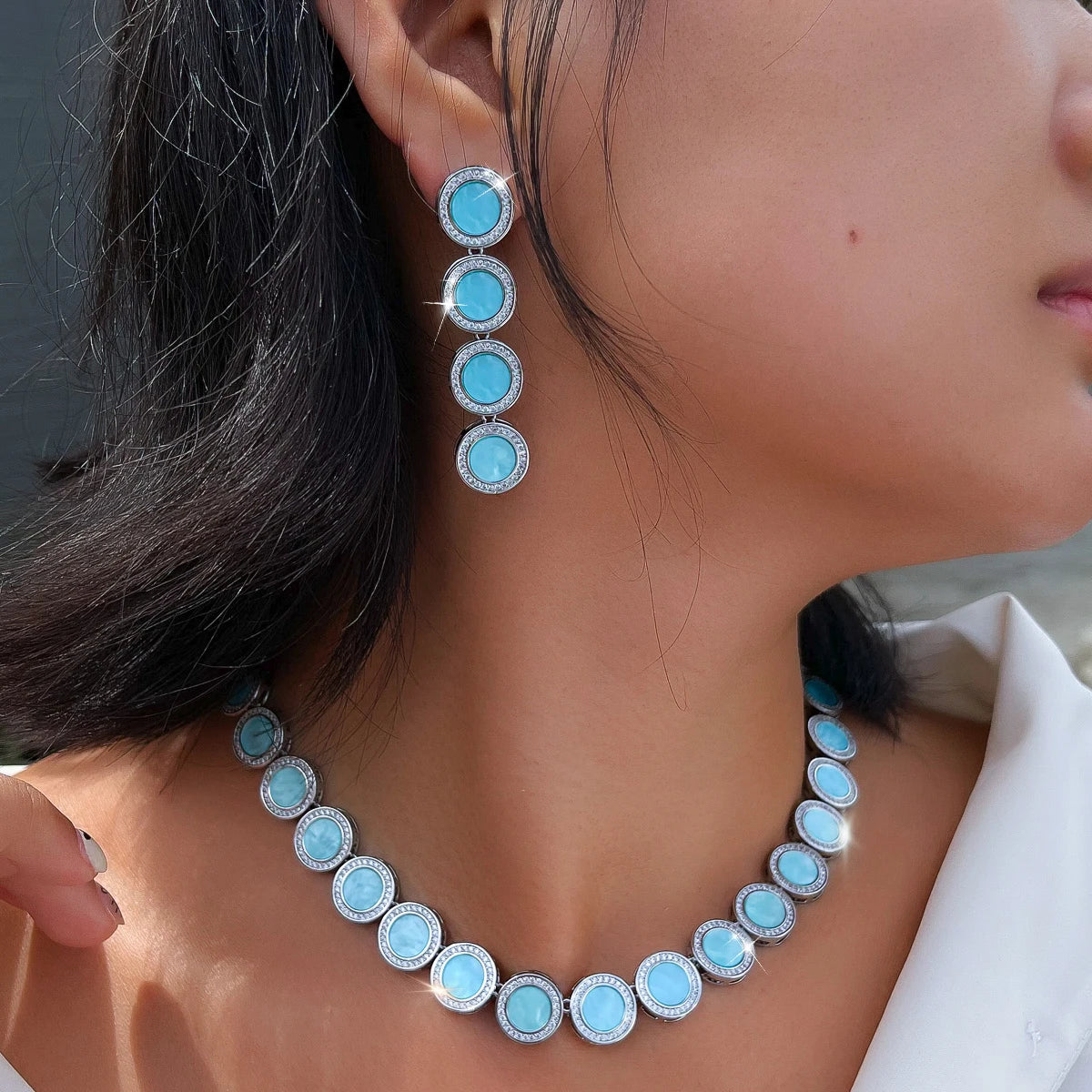 Light blue round halo necklace with matching four-stone drop earrings