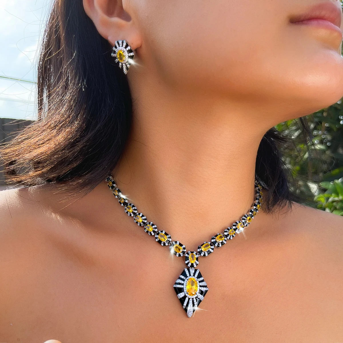 Yellow zircon and black enamel necklace and earring set, shown worn with a geometric pendant.