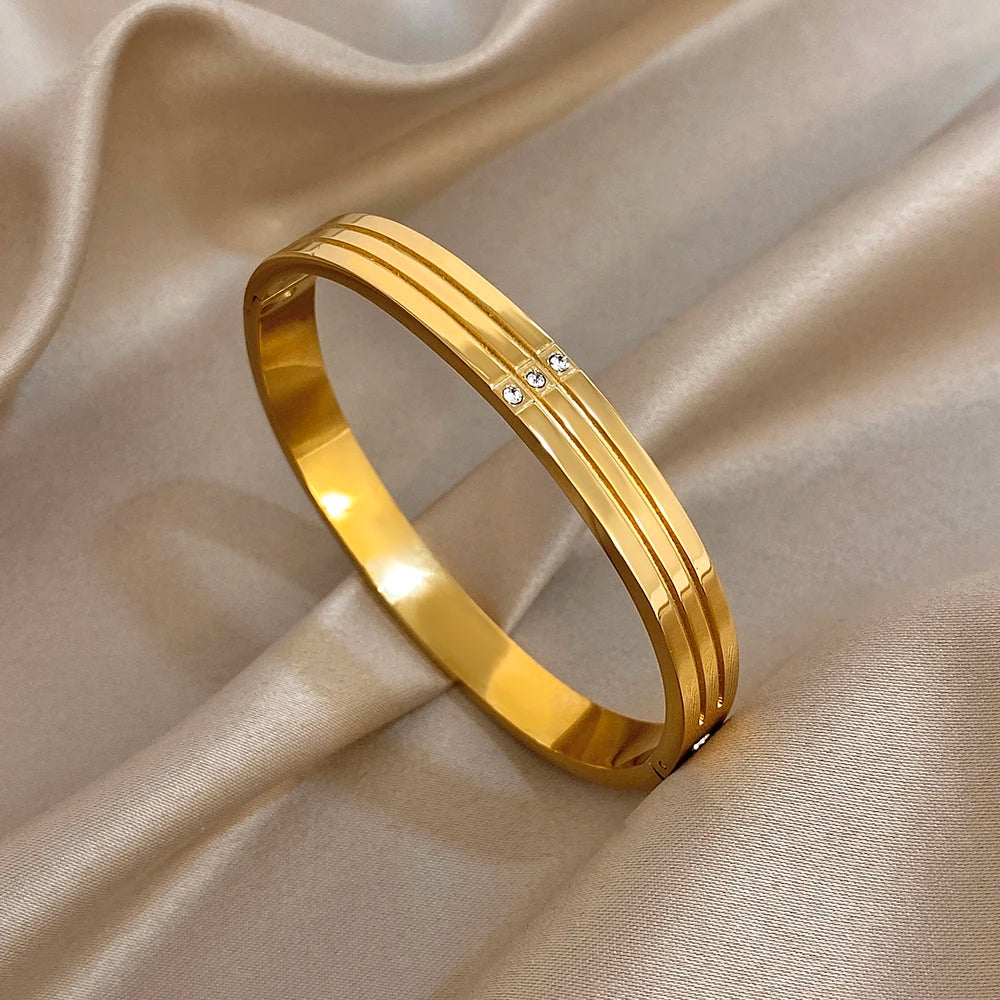 Gold-tone stainless steel wide cuff bangle with crystal stripe on front