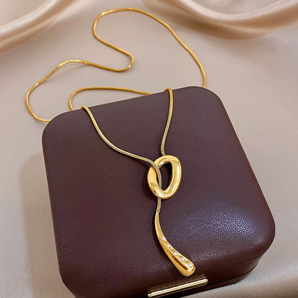Gold knot and waterdrop pendant necklace with snake chain and crystal details