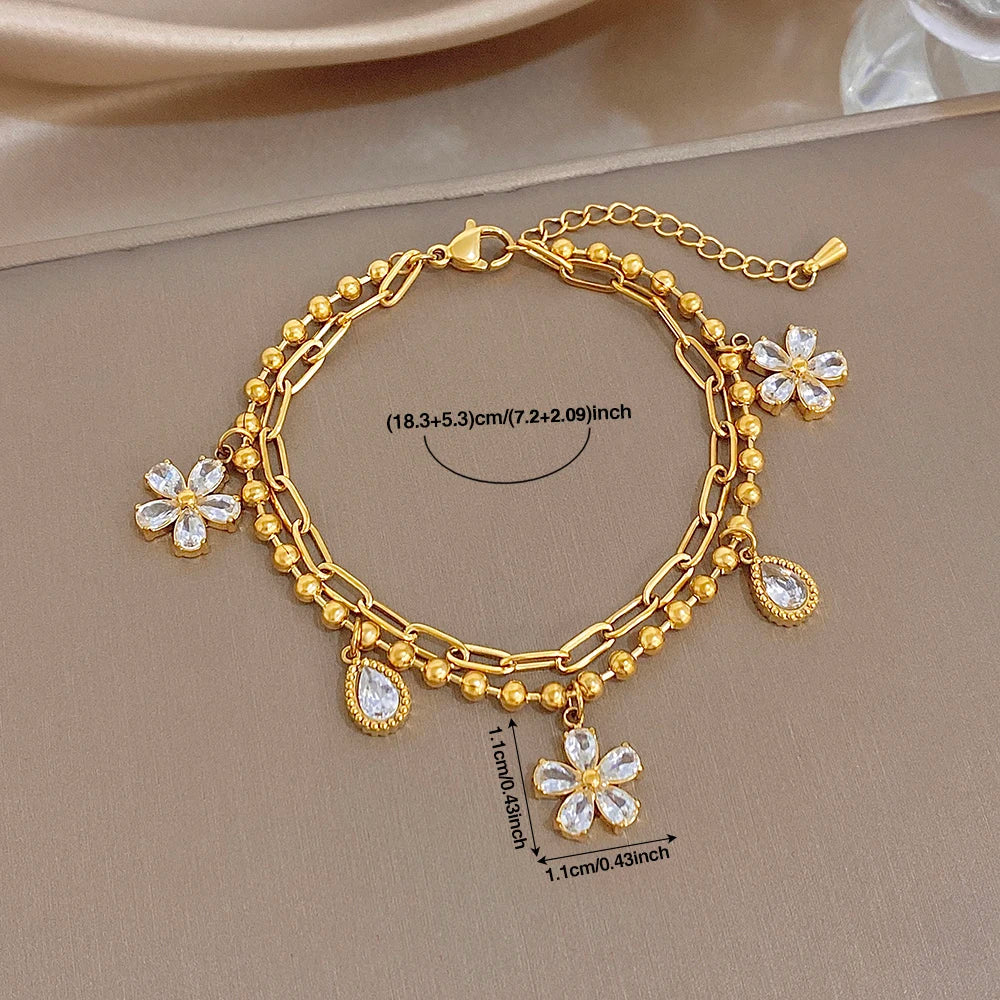 Gold-plated chain bracelet with crystal flower charms and teardrop drops, adjustable fit
