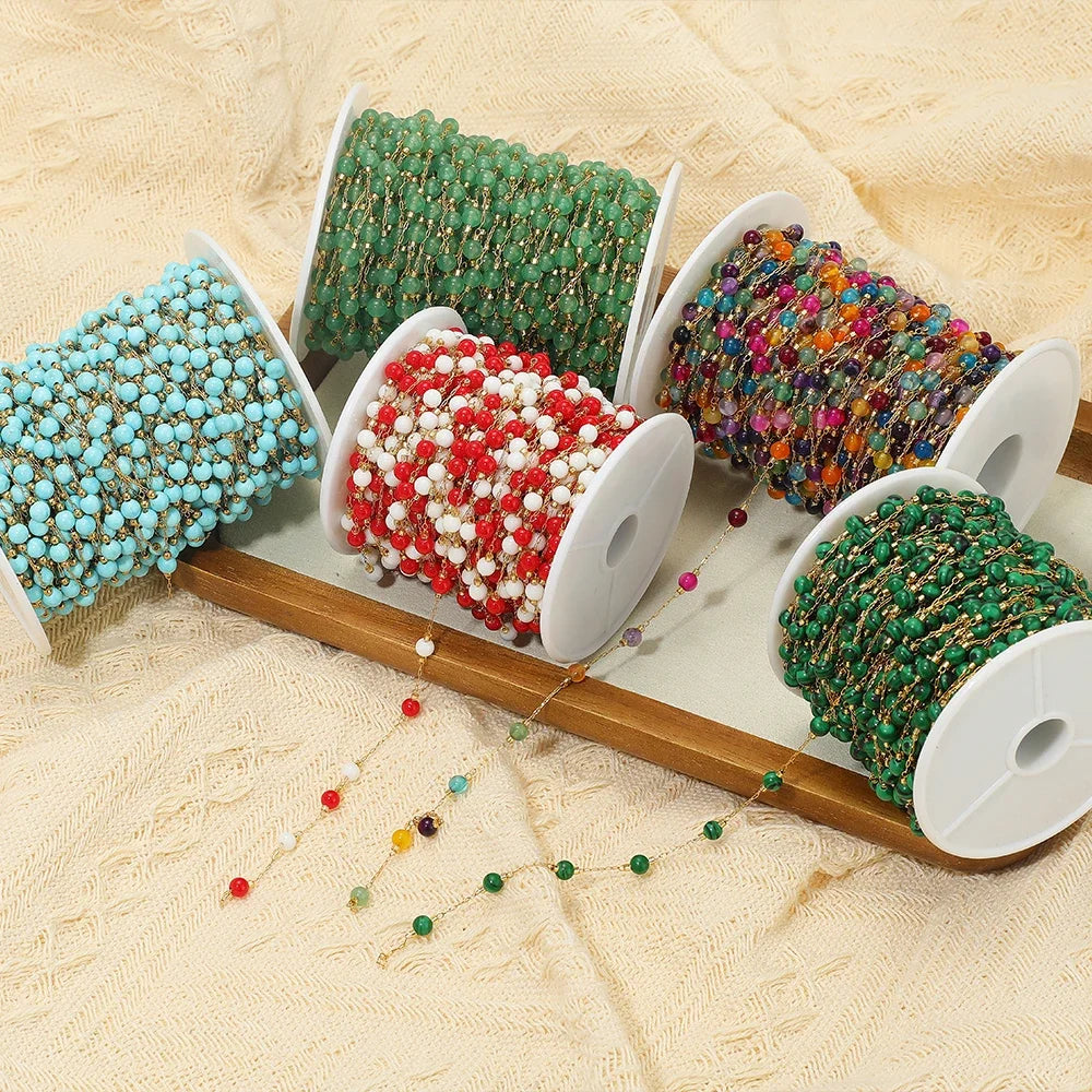 Colorful bead chain bulk on white spools with gold-tone links and mixed beads