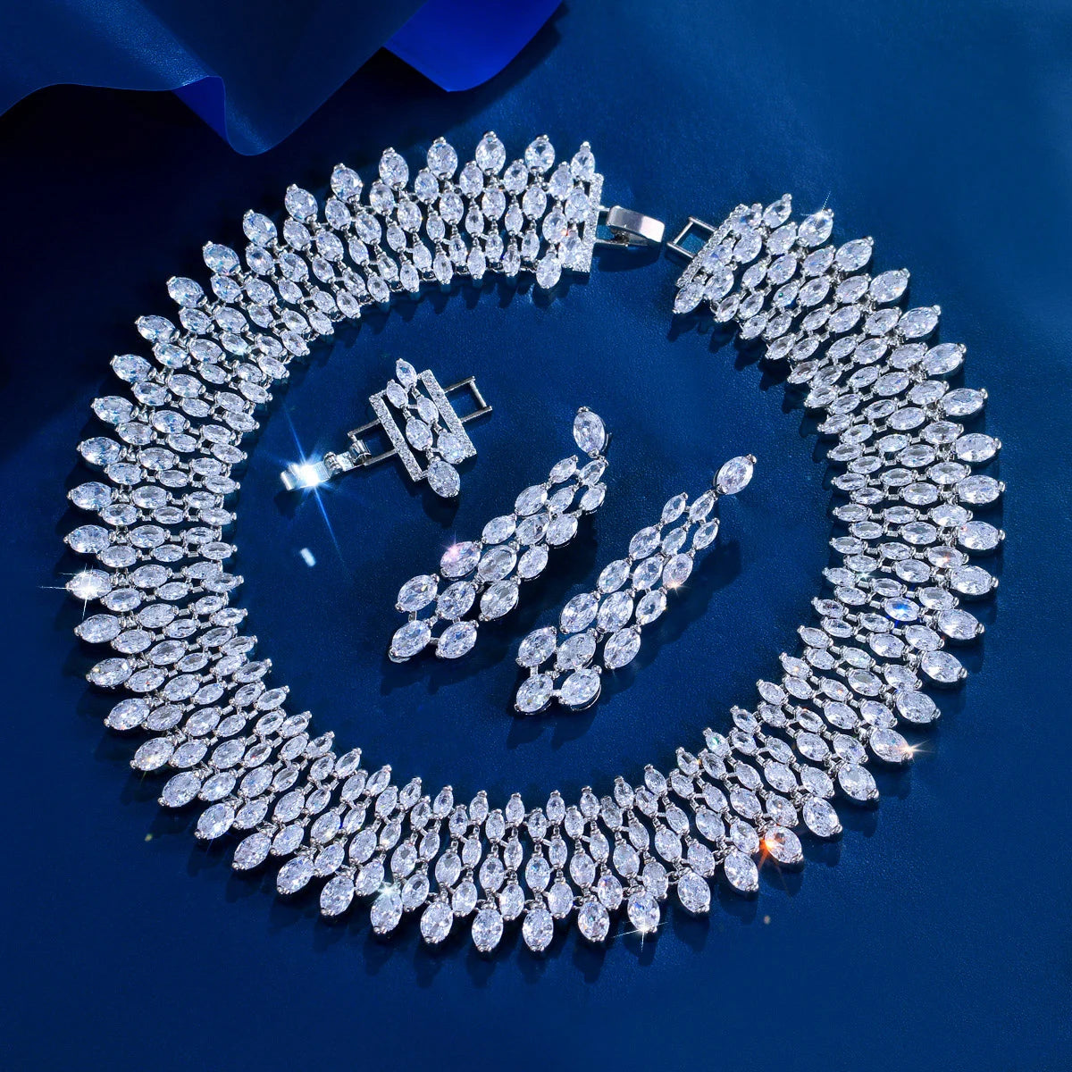Cubic zirconia pave jewelry set laid flat: wide teardrop necklace, matching drop earrings
