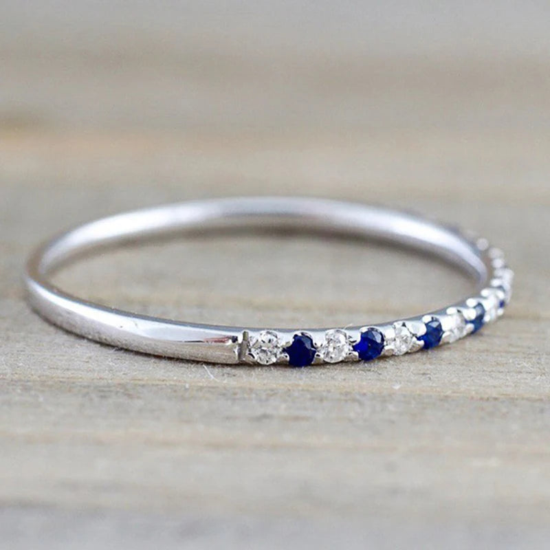 Silver ring with alternating blue and clear CZ stones on the band