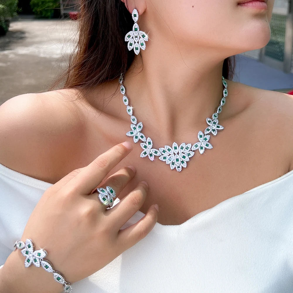 Green zirconia floral necklace with drop earrings, ring, and bracelet on model