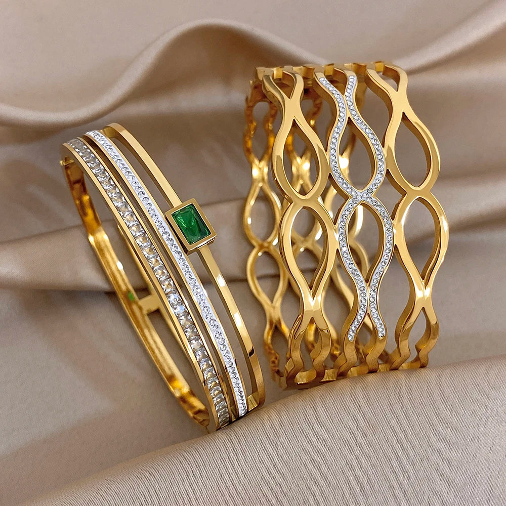 Gold-tone geometric wide cuff bracelet with clear stones and a green square detail
