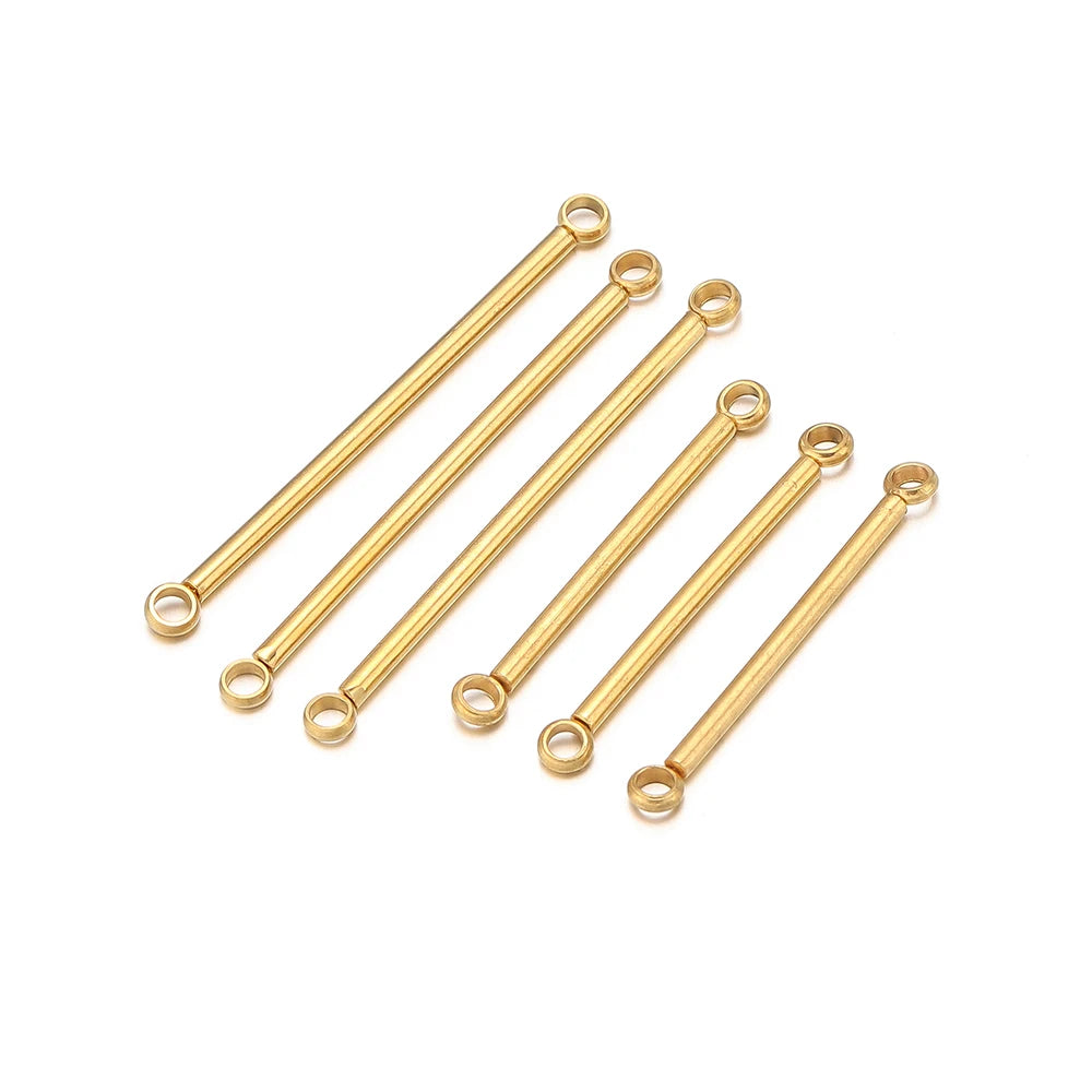 Gold stainless steel double-cylinder rod earring connectors laid out, circular loops at ends