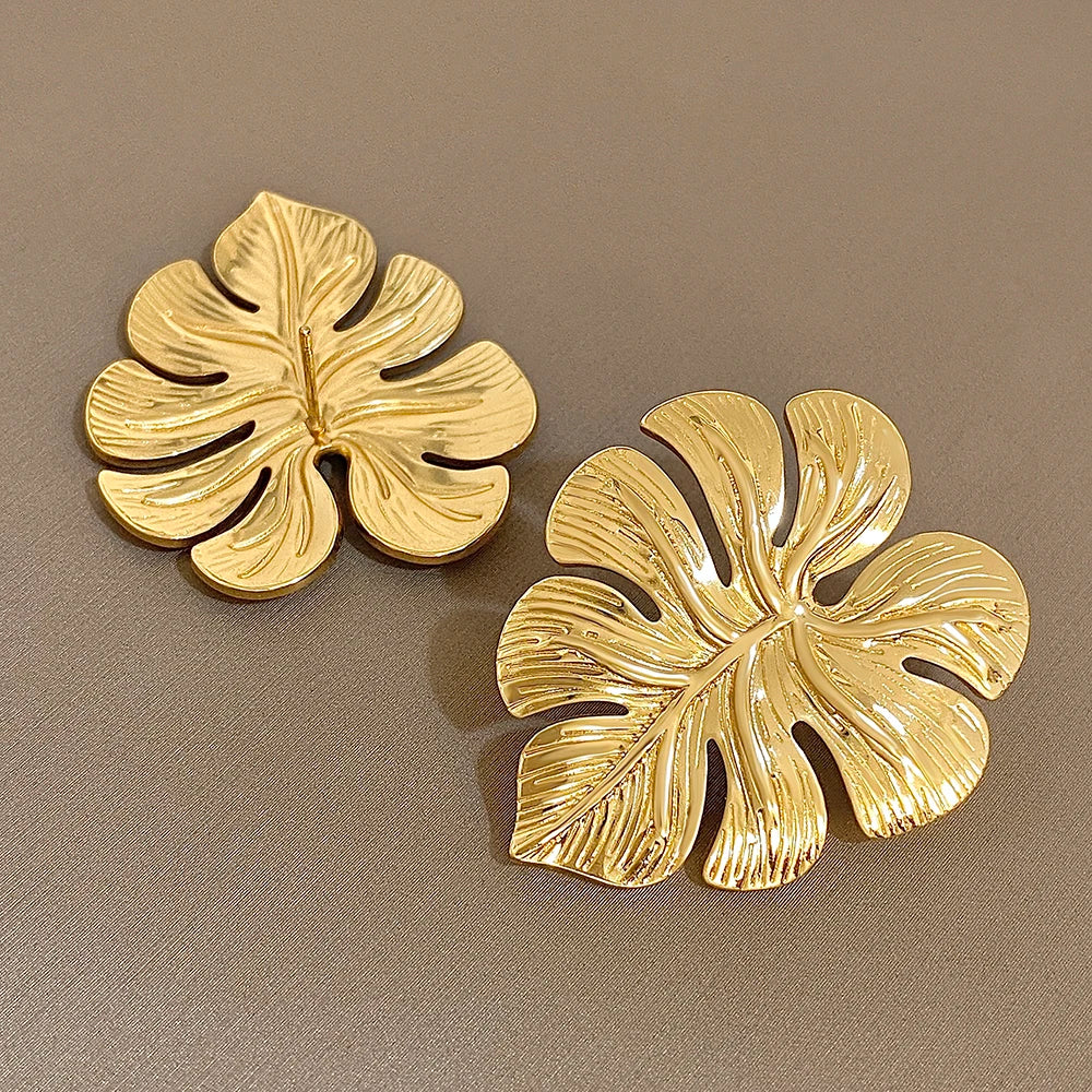 Gold leaf earrings showing their textured fronts and smooth backs