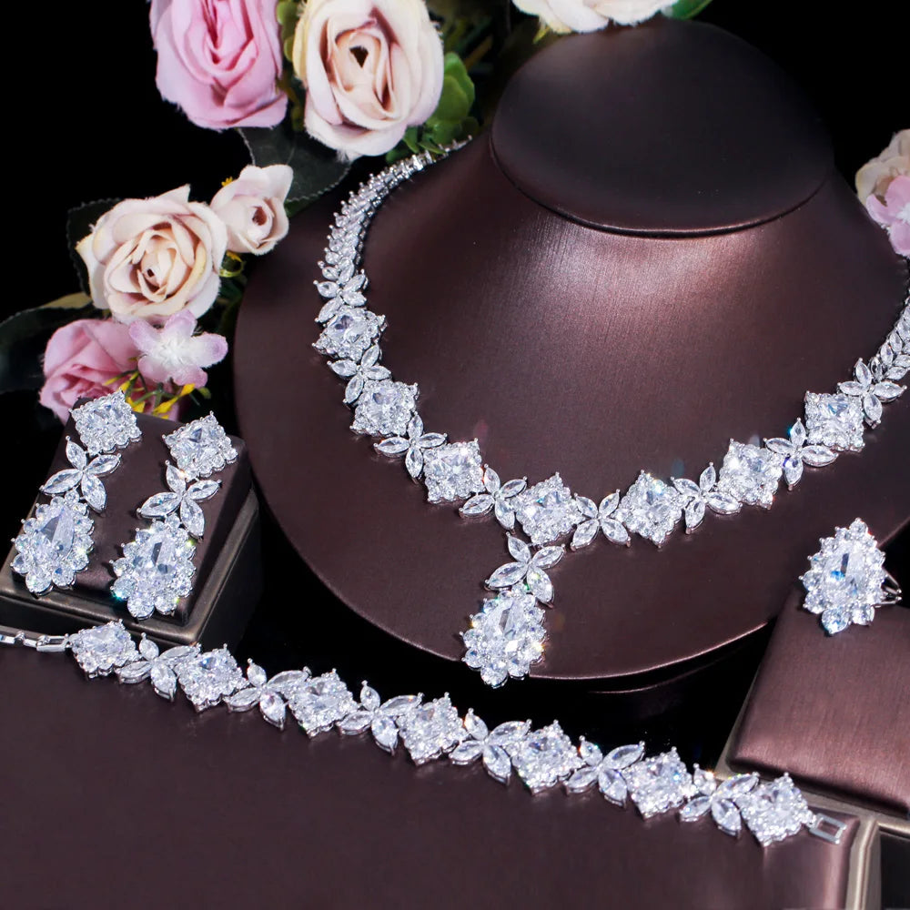 Silver-tone green CZ necklace with matching earrings and bracelet set on jewelry stand