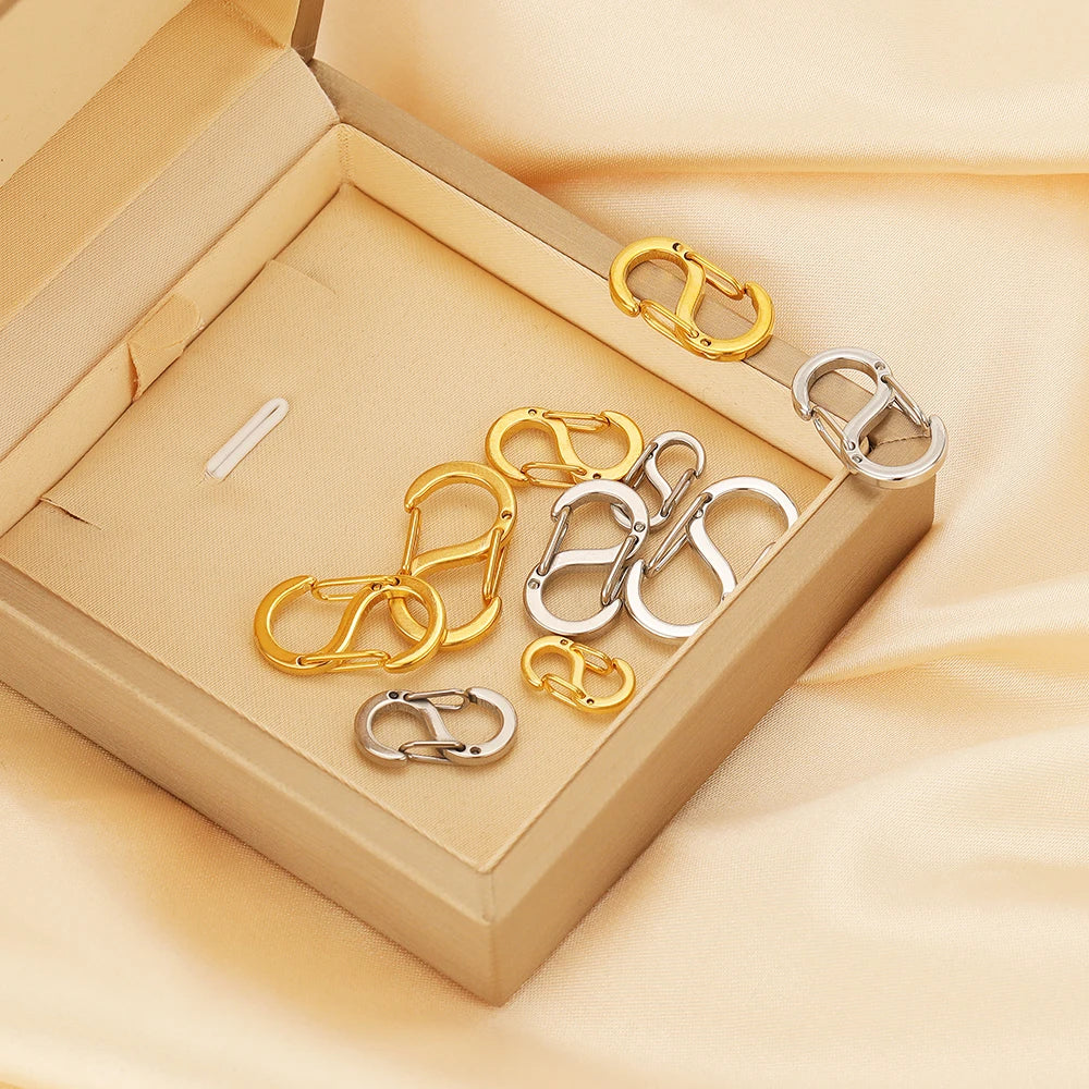 Letter S spring lobster clasps in gold and silver inside a light gift box