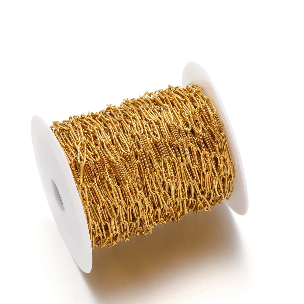 Gold-tone oval flat chain on a spool, cross/paperclip style links