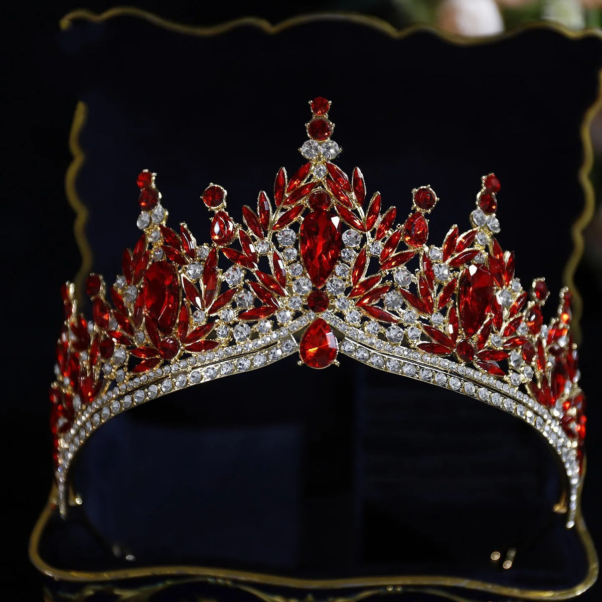 Red gemstone tiara with silver rhinestone band and ornate leaf-like crystal fringe
