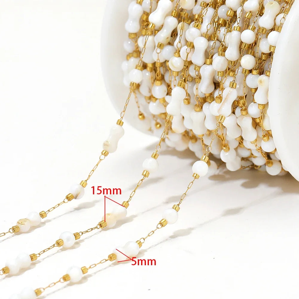 Shell bead chain with white cross-shaped shell pieces and gold-tone links (15mm/5mm marked)