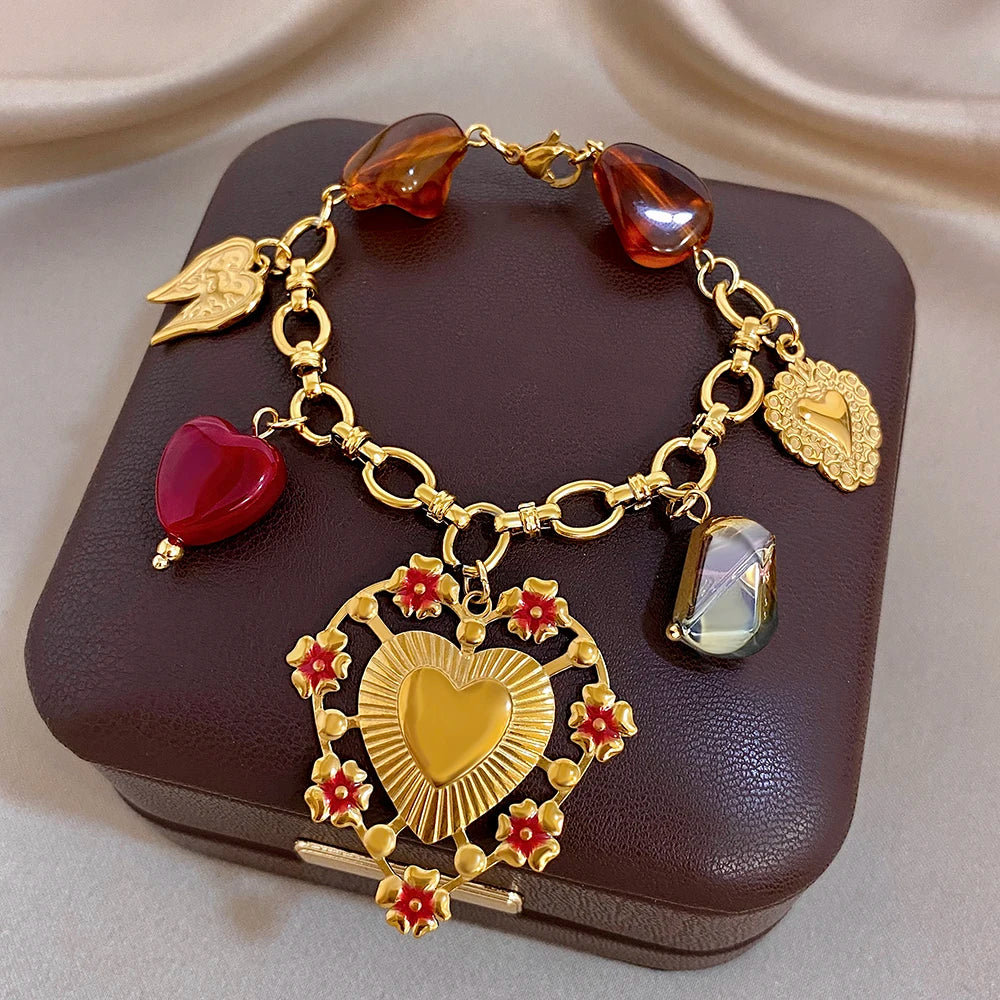 Gold-tone heart charm bracelet with red heart beads, amber teardrop beads, and heart medallion