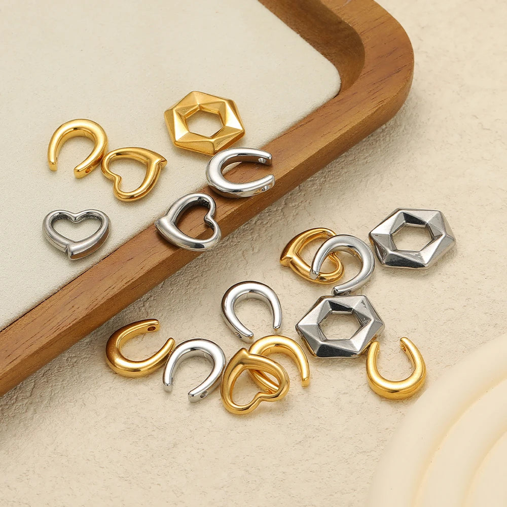 Assorted U-shaped heart charms and hexagon pendants in gold and silver stainless steel