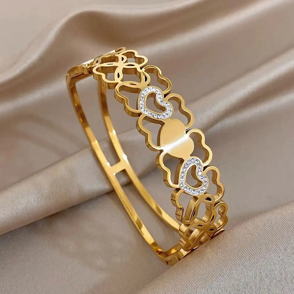 Gold cuff bangle with hollow heart link design and clear rhinestone accents
