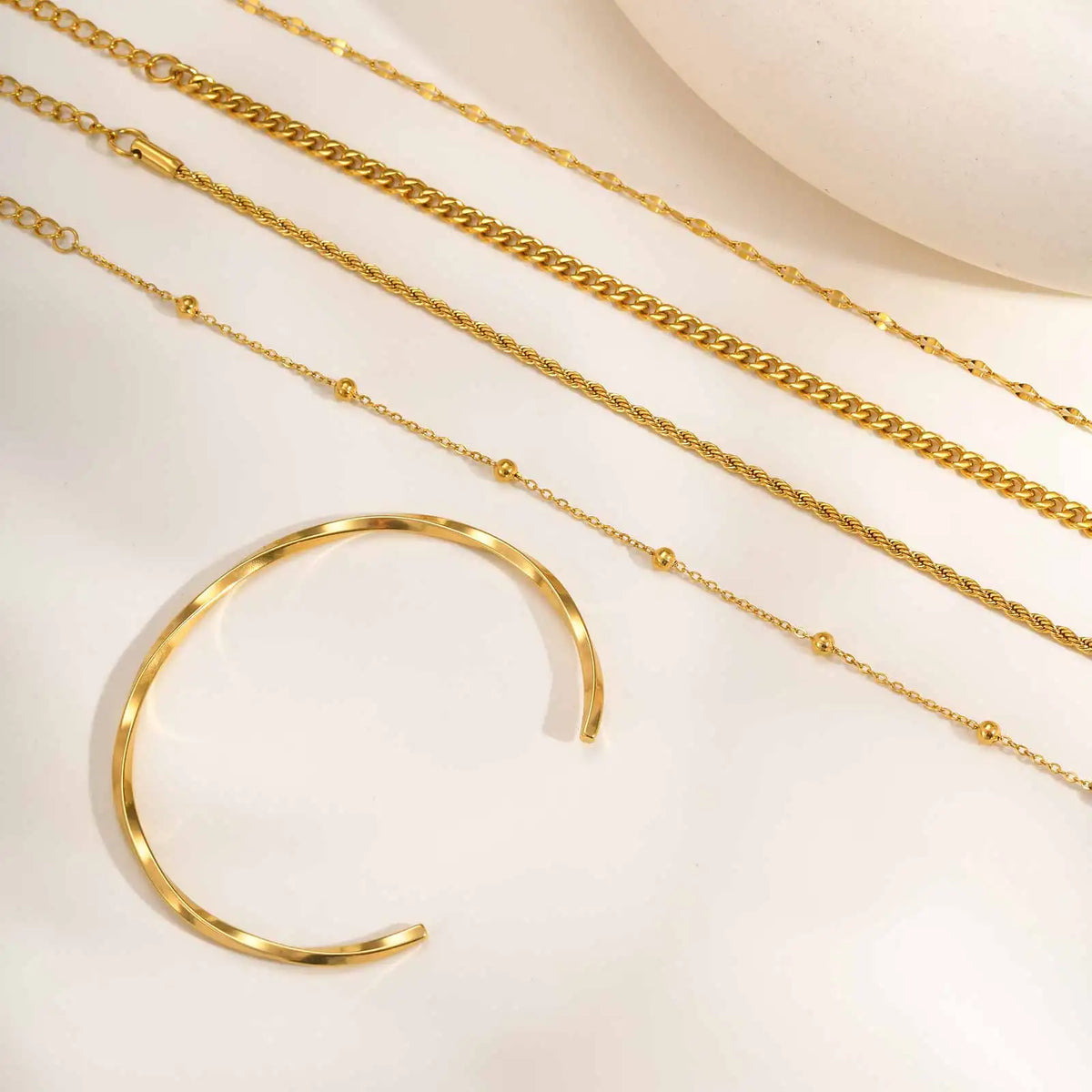 Set of thin gold tone chain bracelets with mixed links and secure clasp ends