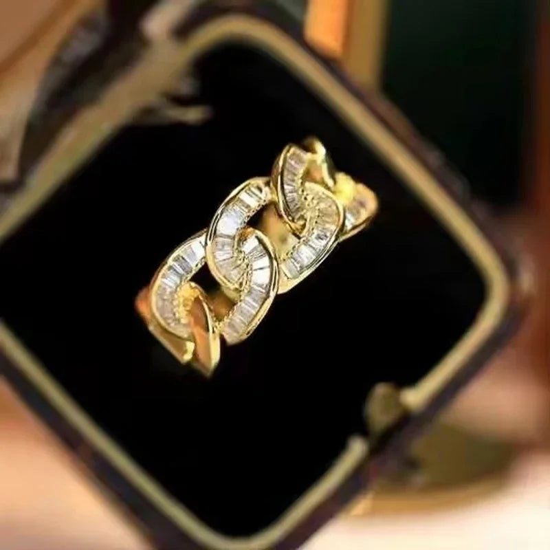 Gold-tone chain-link ring with round cubic zirconia settings, close-up